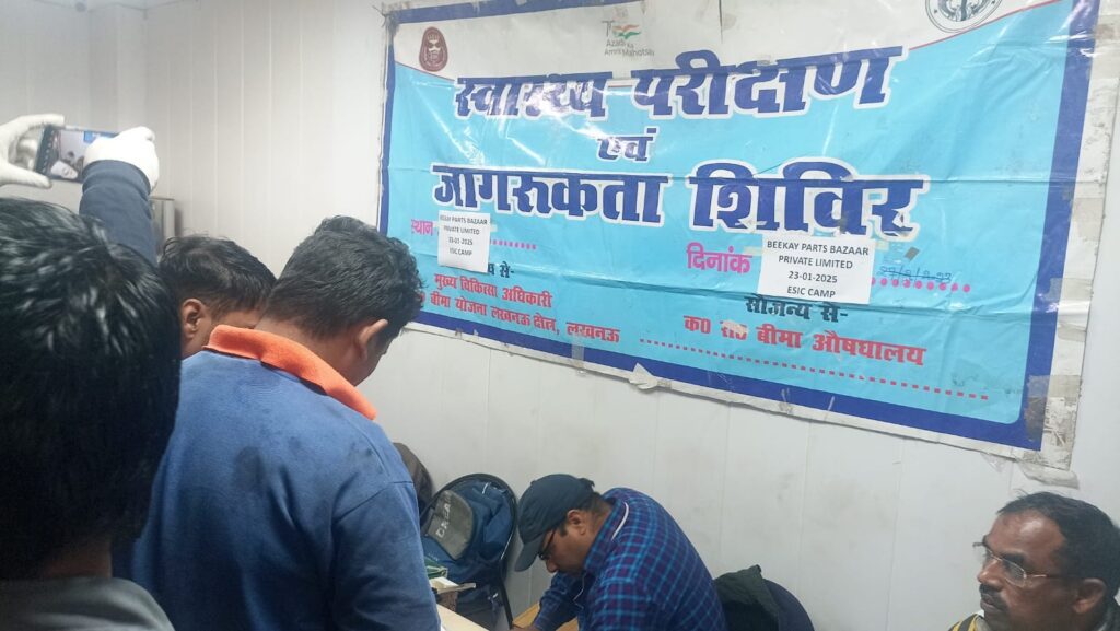 "Employees participating in the ESIC Medical Camp at Beekay Group, with banners and medical equipment in the background."